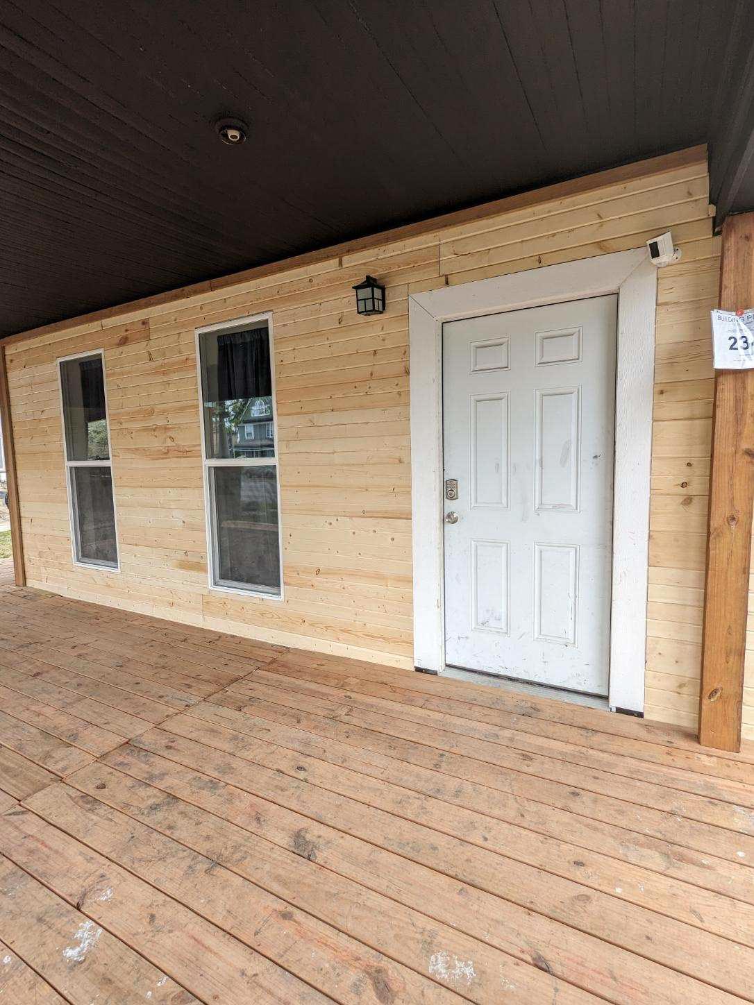 Covered porch entry with matching wood deck and custom exterior details in Omaha custom home